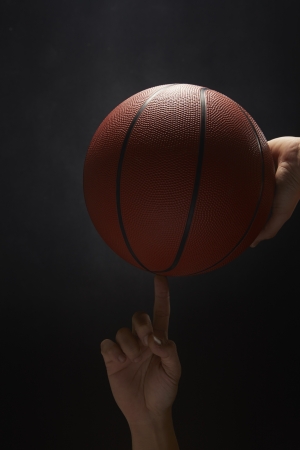 Basketball balancing on a human's fingerの写真素材