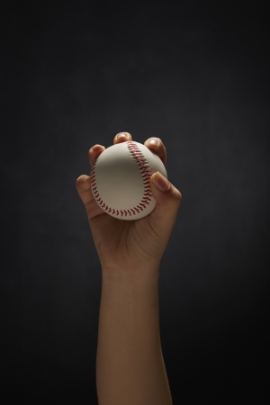 Human hand holding a baseballの写真素材