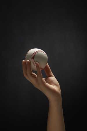 Human hand holding a baseballの写真素材