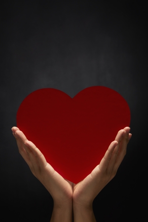 Human hand holding a cut out heartの写真素材