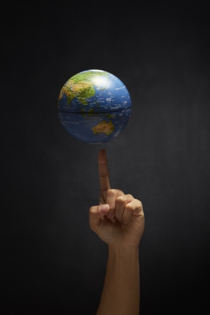 Globe balancing on an index fingerの写真素材