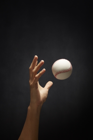 Human hand tossing a baseballの写真素材