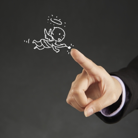 Index finger pointing at an illustration of an angelの写真素材