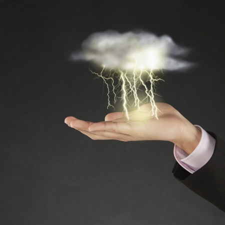 Thunder and lightning striking above human handの写真素材