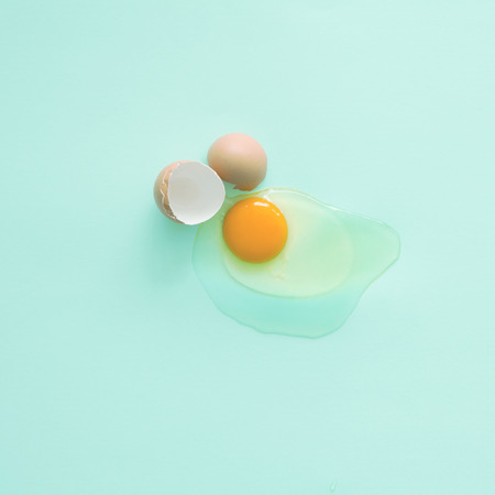 Broken egg on pastel background