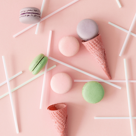 Macarons and wafer cones with straws on pastel backgroundの写真素材
