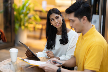 Young Asian adults in a cafe with a contract