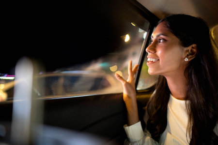 Young Indian woman looking outside through window in a car