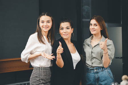 Young women in office attire smiling at the camera