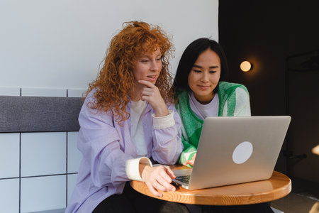 Young women looking at a laptop together