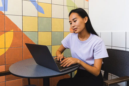 Young Asian woman using a laptop in the cafe