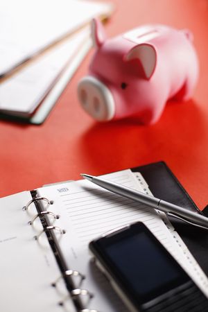 Organizer with cellphone, pen and piggy bankの写真素材