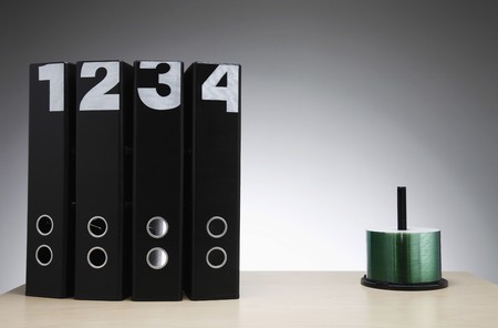 Files and a stack of compact discs on spindle