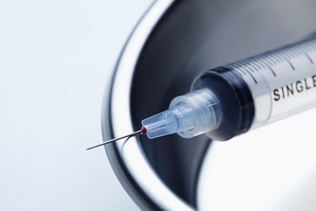 Syringe in kidney dishの写真素材