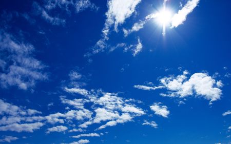 sun and beautiful clouds on blue skyの写真素材
