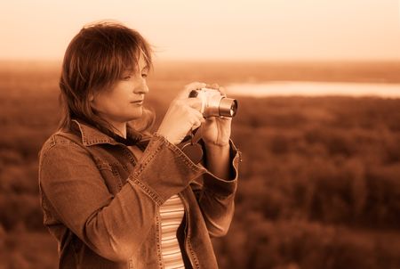 Woman tourist with camera. Early morning. Sepia tones.の写真素材
