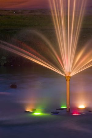 The fountain in park is shined by multi colored lanterns. Long shutterの写真素材