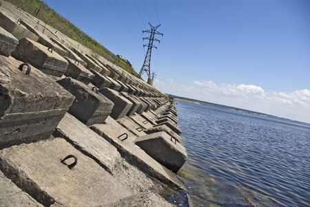 High voltage wires it is high in the blue sky. Coast of the big river.の写真素材