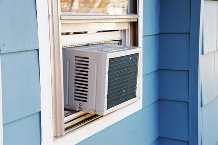 old air conditioner installed on house windowの写真素材