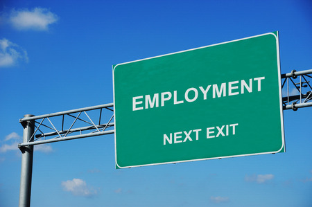 employment green road sign in front of blue skyの写真素材