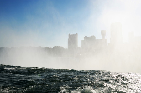 mist from Niagara Falls in the sky before city skylineの写真素材