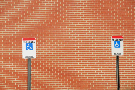 handicap sign in parking area against brick wallの写真素材