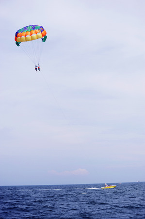parasailing in summer beach by speed boat, vertical compositionの写真素材