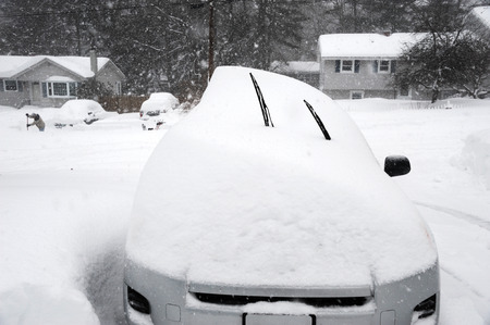 car buried under snow after blizzard in residential areaの写真素材