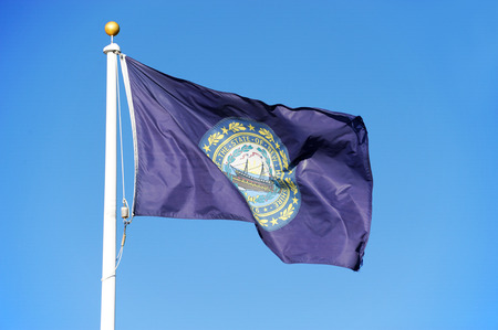 New Hampshire state flag waving under blue skyの写真素材
