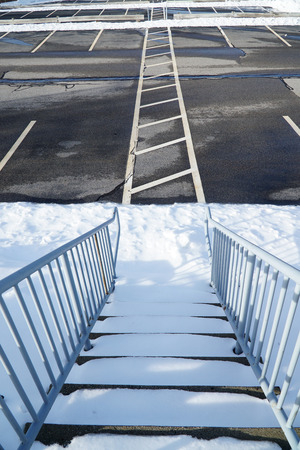 high angle view on stairs in empty parking lot with snow removedの写真素材