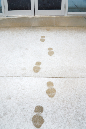 footprint on snow in front of office doorの写真素材