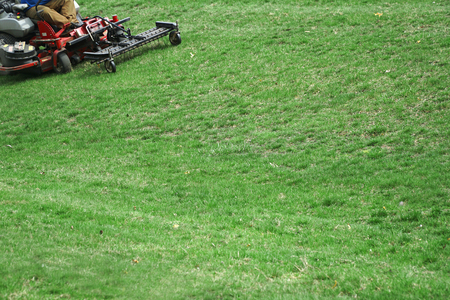 Outdoor worker working on mowing the lawnの写真素材