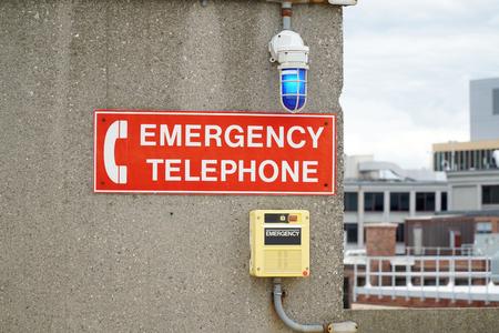 emergency telephone and warning sign in the wall of parking lot