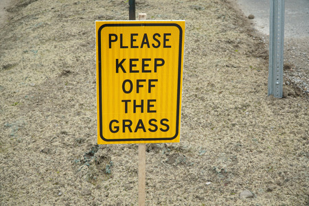 please keep off grass warning sign on the yellow meadowの写真素材