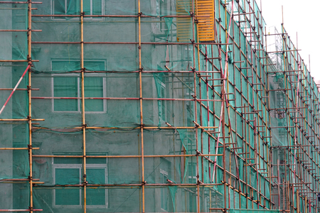 Construction scaffolding outside urban building at construction siteの写真素材