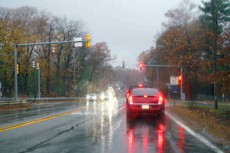 Cars and light reflecting on rainy streetの写真素材