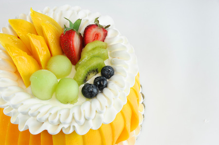 colorful fruit birthday cake isolated on white backgroundの写真素材