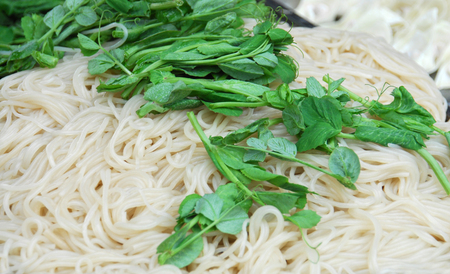 Raw noodle and fresh vegetable as food backgroundの写真素材