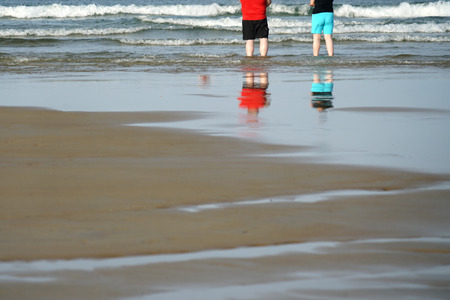close up on a couple standing in the beach with reflectionの写真素材