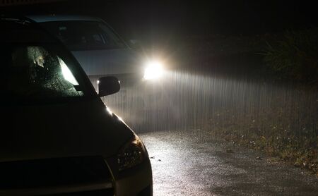 Heavy rain under headlight of vehicle at nightの写真素材