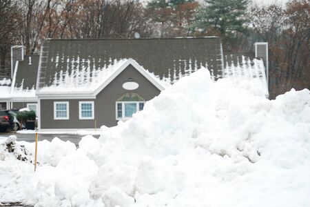 snow pile in front of winter house after snow storm