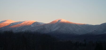 panoramic scenery of snow mountains with red sunlight on peak