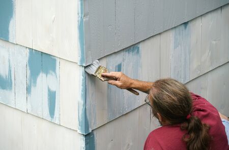 close up on handyman painting the exterior wall of the houseの写真素材