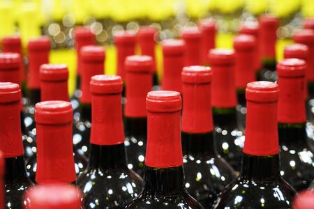 close up on red wine bottles in rowsの写真素材
