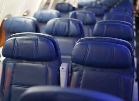 Rows of blue leather seats in the airplane