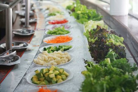 fresh salad in the plate in a row in restaurantの写真素材