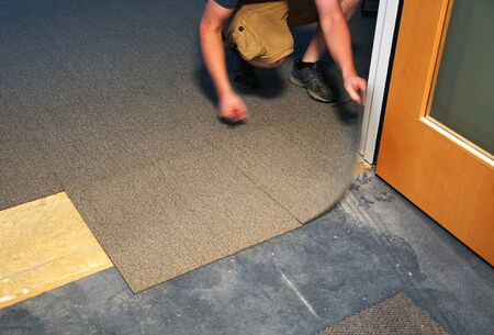 handyman installing carpet in the office building