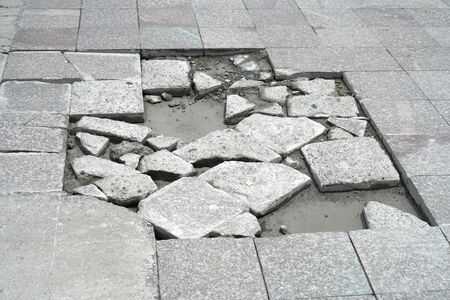 close up broken sidewalk road surface paved with bricksの写真素材