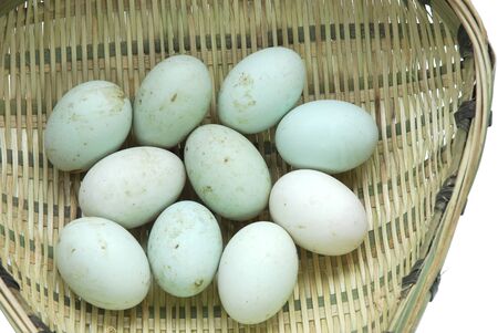 fresh duck eggs in the bamboo sieve isolated on white backgroundの写真素材