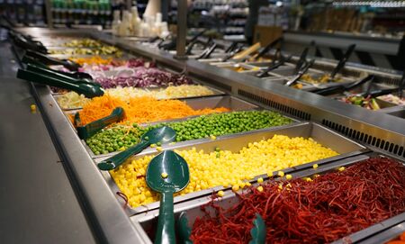 variety of colorful fresh vegetable salad in container in restaurantの写真素材
